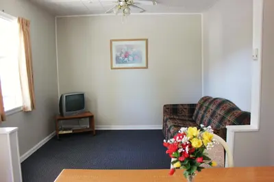 a living room with a couch and a tv at Boundary Motel in Osoyoos
