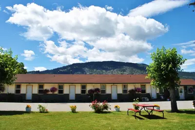 a building with a picnic table in front of it at Boundary Motel in Osoyoos