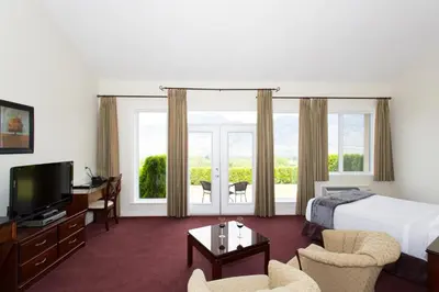 a hotel room with a bed and a television at Shiraz Villa in Osoyoos