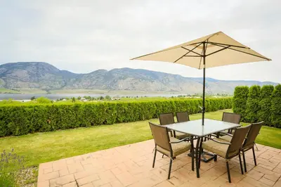 a table and chairs with an umbrella on a patio at Shiraz Villa in Osoyoos