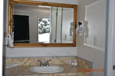 a bathroom with a sink and a mirror at Evening Star Motel in Greenwood