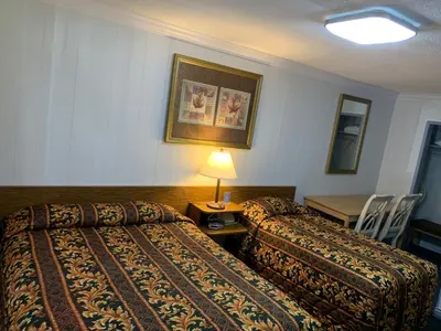 a hotel room with two beds and a table with a lamp at Evening Star Motel in Greenwood