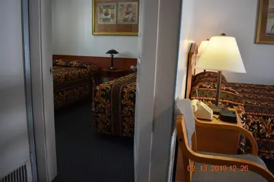 a hotel room with a bed and a desk with a phone at Evening Star Motel in Greenwood