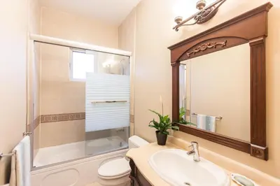 a bathroom with a sink and a toilet and a mirror at An Yang House in Burnaby