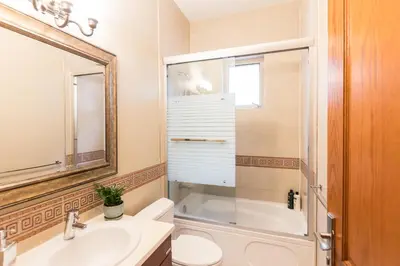 a bathroom with a toilet and a sink and a mirror at An Yang House in Burnaby