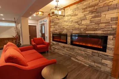 a living room with a large stone fireplace at The Kanata Inns Invermere in Invermere