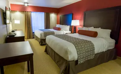 a hotel room with two beds and a table at The Kanata Inns Invermere in Invermere