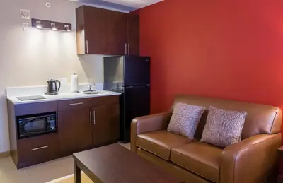 a living room with a couch and a kitchen at The Kanata Inns Invermere in Invermere