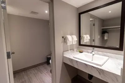 a bathroom with a sink and a mirror at BCM Inns Fort McMurray - Downtown in Fort McMurray