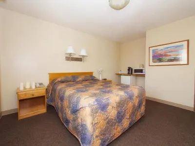 a bedroom with a large bed in a room at Best Maple Inn - Drayton Valley in Drayton Valley