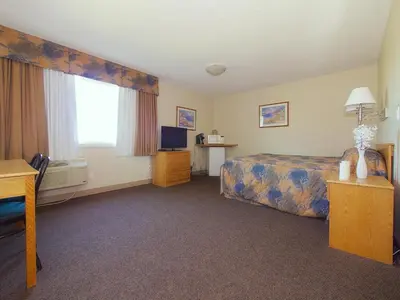 a hotel room with a bed and a television at Best Maple Inn - Drayton Valley in Drayton Valley