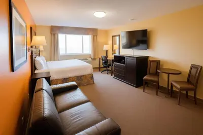 a hotel room with a bed and a couch at Best Maple Inn - Drayton Valley in Drayton Valley
