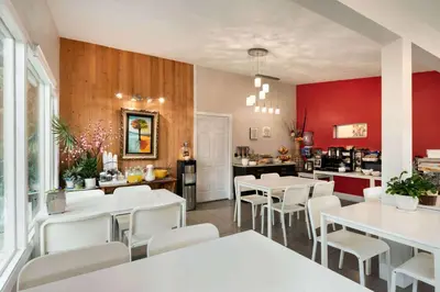 a restaurant with white tables and white chairs at Thriftlodge Edmonton in Edmonton