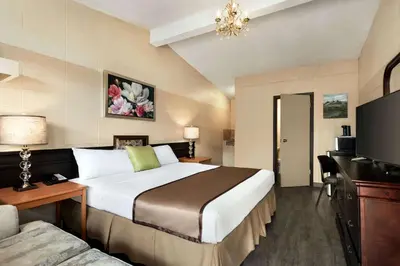 a hotel room with a large bed and a couch at Thriftlodge Edmonton in Edmonton