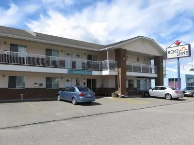 a hotel with two cars parked in a parking lot at BCMInns - Coleman in Coleman
