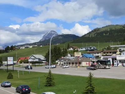 a town with a parking lot and a mountain at BCMInns - Coleman in Coleman
