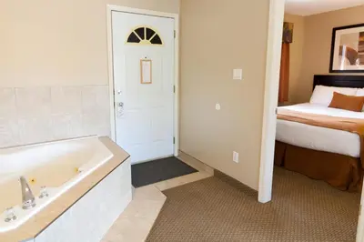 a bathroom with a bath tub and a bed at BCMInns - Coleman in Coleman
