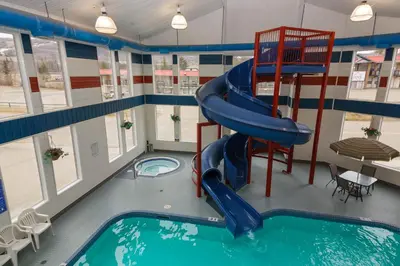 a indoor swimming pool with a slide in a building at BCMInns - Peace River in Peace River