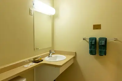 a bathroom with a sink and a mirror at BCMInns - Fort McMurray - Rusty's in Fort McMurray