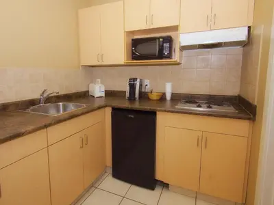 a small kitchen with a sink and a microwave at BCMInns - Fort McMurray - Rusty's in Fort McMurray
