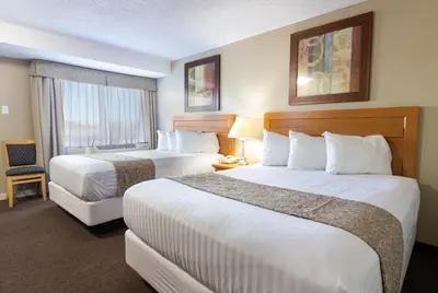 a hotel room with two beds and a window at BCMInns - Lloydminster in Lloydminster