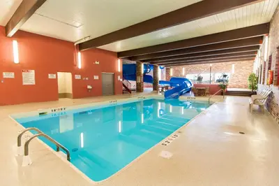 a large swimming pool with a slide in a building at BCMInns - Lloydminster in Lloydminster