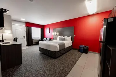 a hotel room with a bed and a red wall at The Kanata by BCMInns - Hinton in Hinton