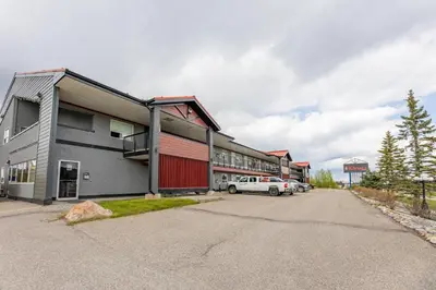 a building with a car parked in a parking lot at The Kanata by BCMInns - Hinton in Hinton