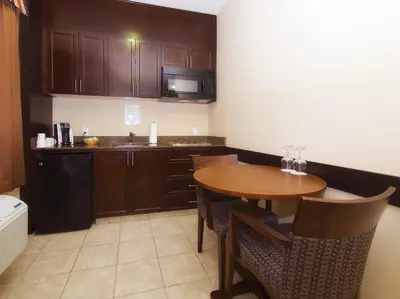 a kitchen with a wooden table and a kitchen with a sink at BCMInns - Lac La Biche in Lac La Biche