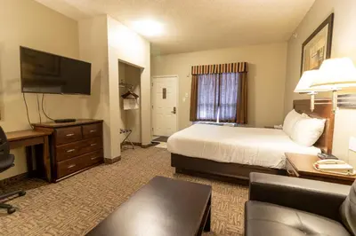 a hotel room with a bed and a flat screen tv at BCMInns - Lac La Biche in Lac La Biche