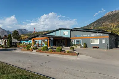 a building on the side of a street with a mountain at Red Tree Lodge in Fernie