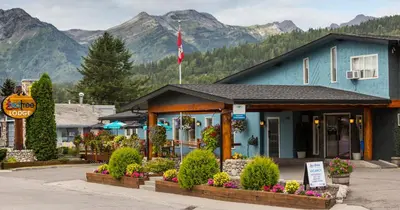 a blue building with flowers in front of it at Red Tree Lodge in Fernie