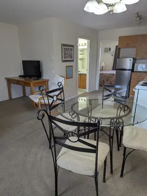 a living room with a glass table and chairs at Summerland Motel in Summerland