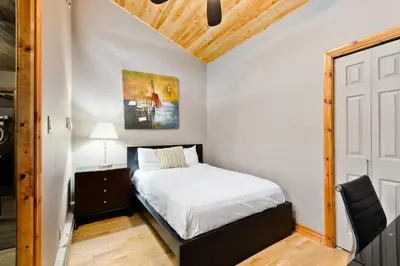 a small bedroom with a bed and a chair at M Lofts in Calgary