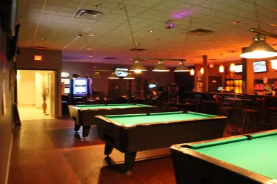 a bar with several pool tables in a room at Ramada by Wyndham Edmonton South in Edmonton