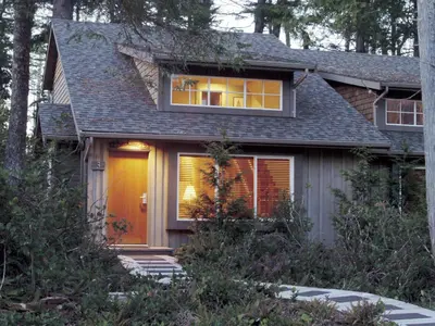 a small house with a yellow door and trees at Long Beach Lodge Resort in Tofino