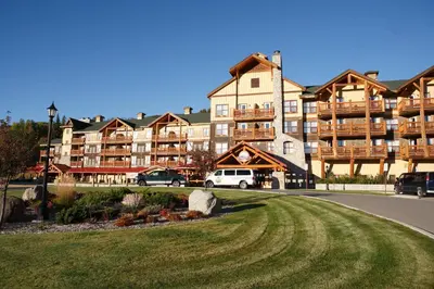a large apartment building with cars parked in front of it at Trickle Creek Lodge in Kimberley