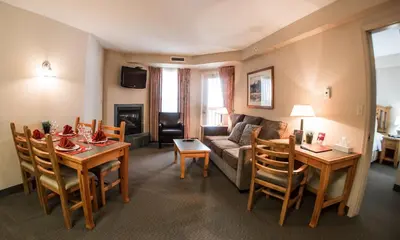 a living room with a couch and a table and chairs at Trickle Creek Lodge in Kimberley