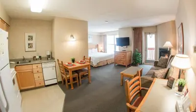a hotel room with a kitchen and a bedroom at Trickle Creek Lodge in Kimberley