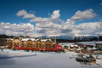 a ski lodge with snow on the ground in front at Trickle Creek Lodge in Kimberley