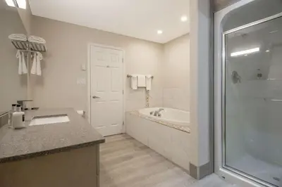 a bathroom with a tub and a sink and a shower at Coast Osoyoos Beach Hotel in Osoyoos