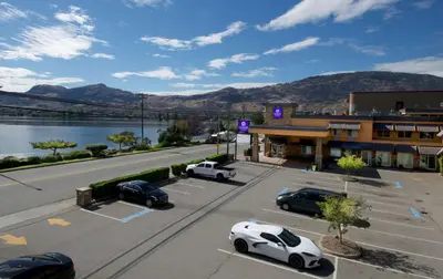 an empty parking lot with cars parked in front of a building at Coast Osoyoos Beach Hotel in Osoyoos