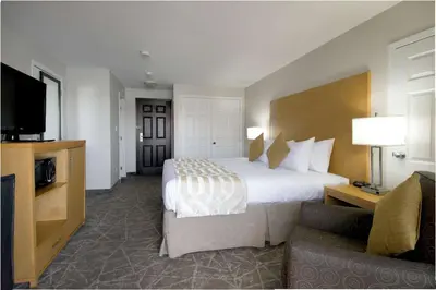 a hotel room with a large bed and a couch at Coast Osoyoos Beach Hotel in Osoyoos