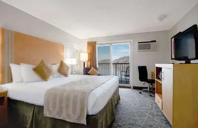 a hotel room with a bed and a flat screen tv at Coast Osoyoos Beach Hotel in Osoyoos