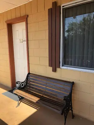 a bench sitting in front of a building with a window at Sun Beach Motel in Osoyoos