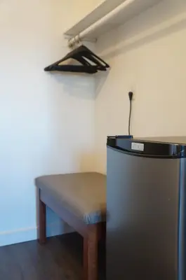 a room with a bench and a refrigerator in a room at Westward Inn & Suites in Langley