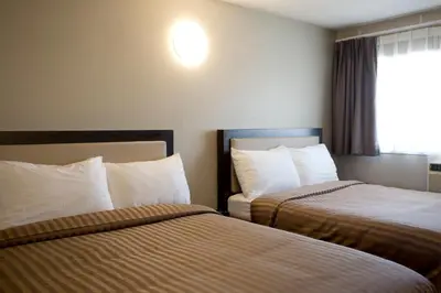 a hotel room with two beds and a window at Valemount Vacation Inn in Valemount