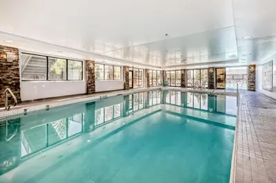 a swimming pool with blue water in a building at Copper Point Resort in Invermere