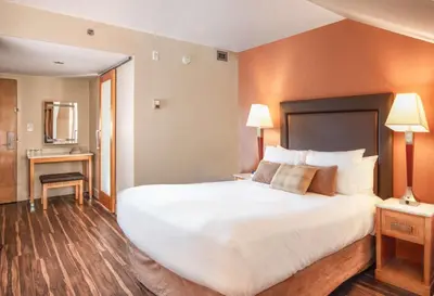 a hotel room with a large bed and a desk at Coast Hillcrest Hotel in Revelstoke