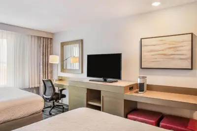 a hotel room with a desk with a flat screen tv at Ramada by Wyndham St Paul AB in St. Paul